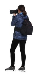 Photographer with backpack and camera taking picture on white background, back view