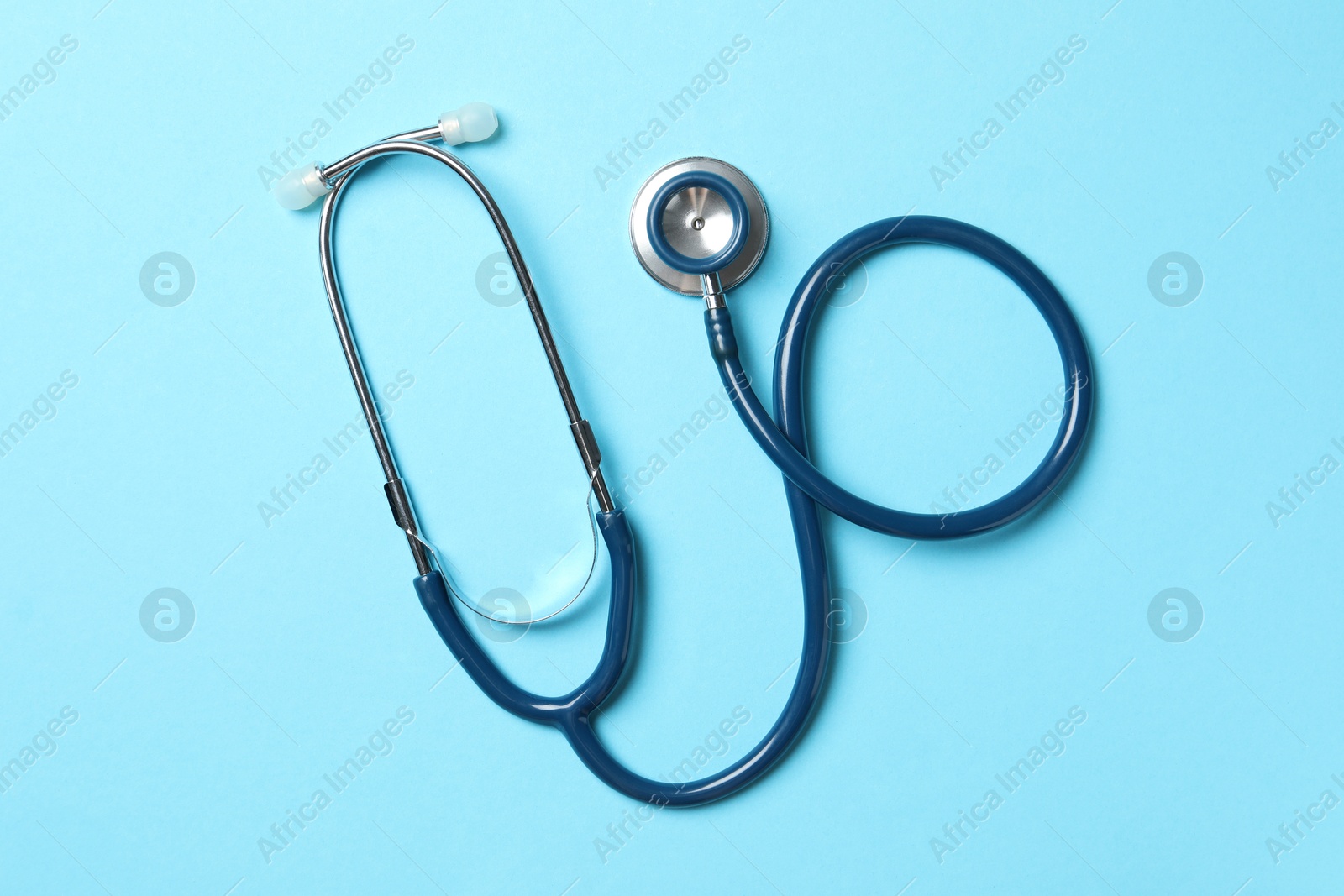 Photo of Stethoscope on light blue background, top view. Medical treatment