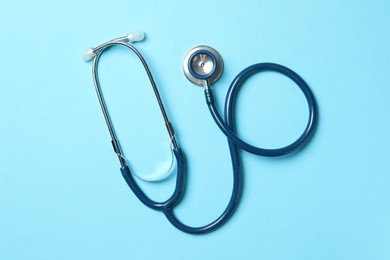 Photo of Stethoscope on light blue background, top view. Medical treatment