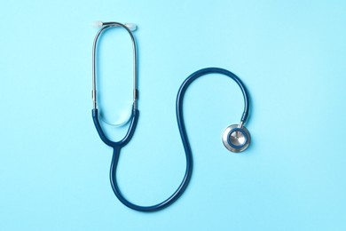 Photo of Stethoscope on light blue background, top view. Medical treatment