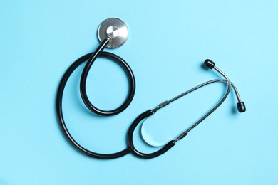 Photo of Stethoscope on light blue background, top view. Medical treatment