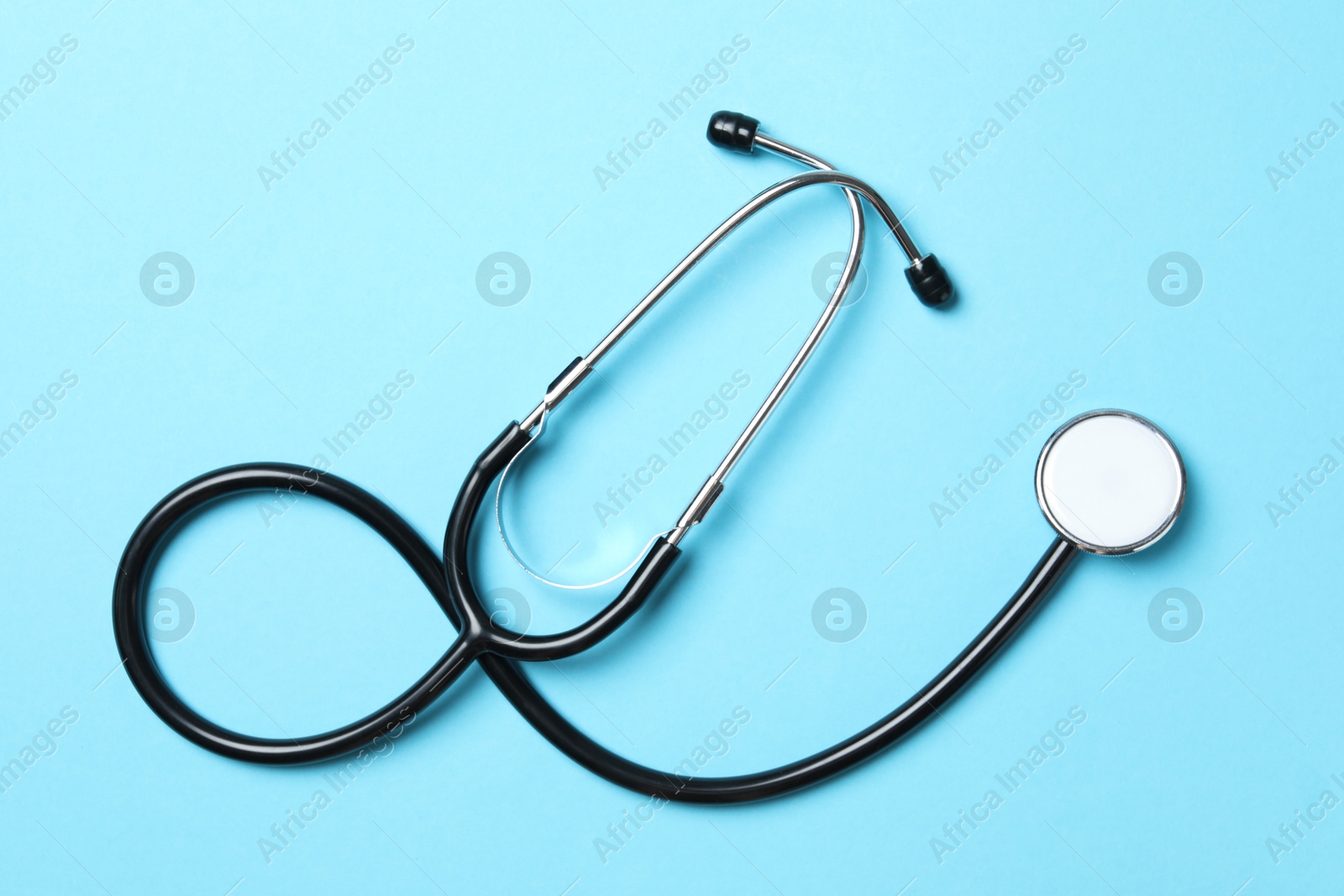 Photo of Stethoscope on light blue background, top view. Medical treatment