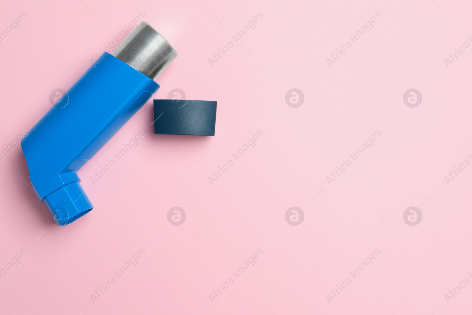 Photo of Asthma inhaler on pink background, top view. Space for text