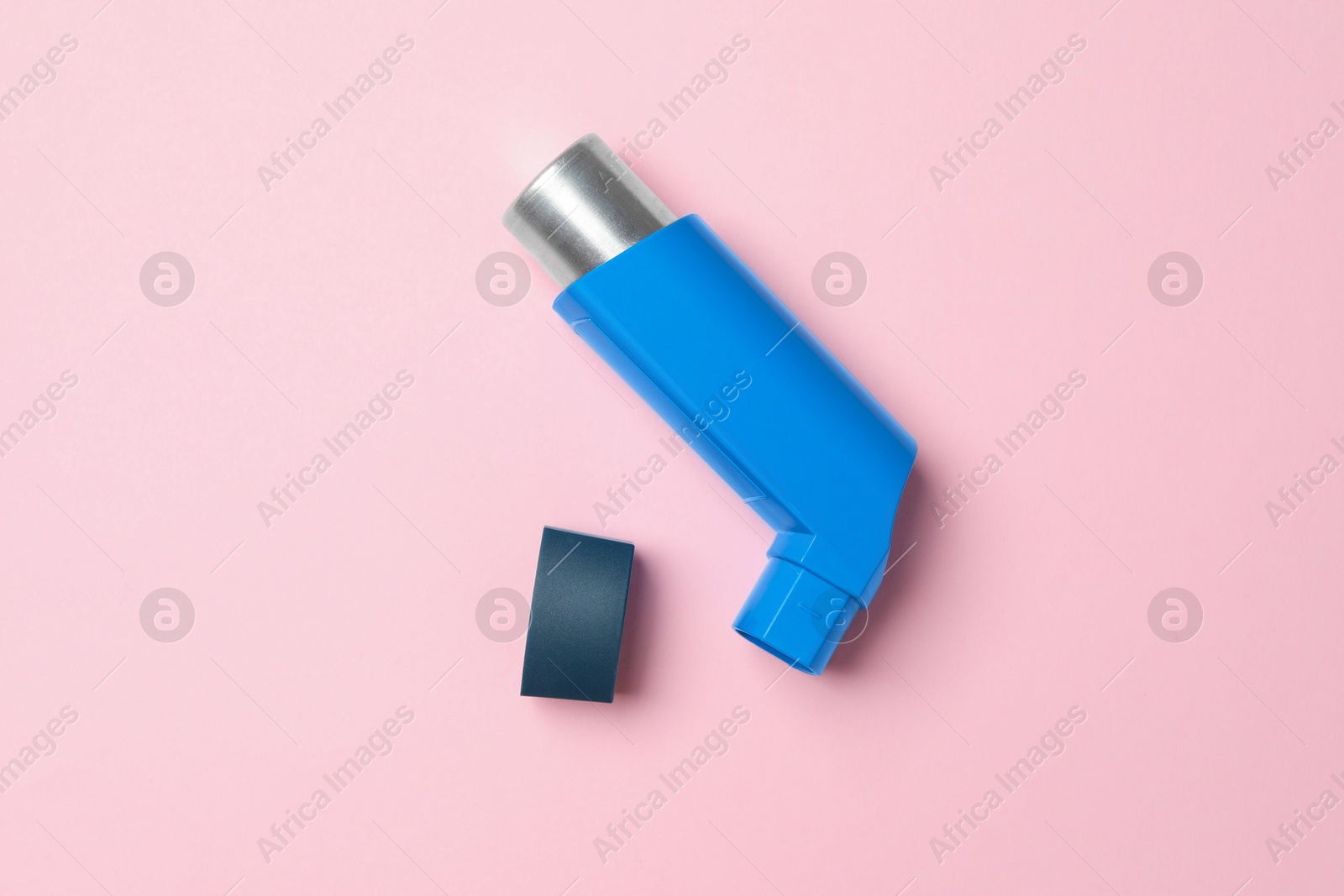 Photo of Asthma inhaler on pink background, top view