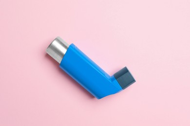 Photo of Asthma inhaler on pink background, top view