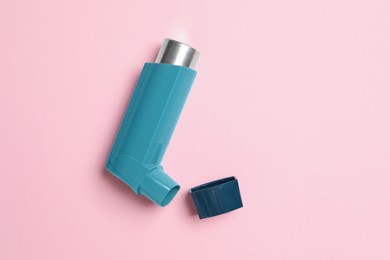 Photo of Asthma inhaler on pink background, top view