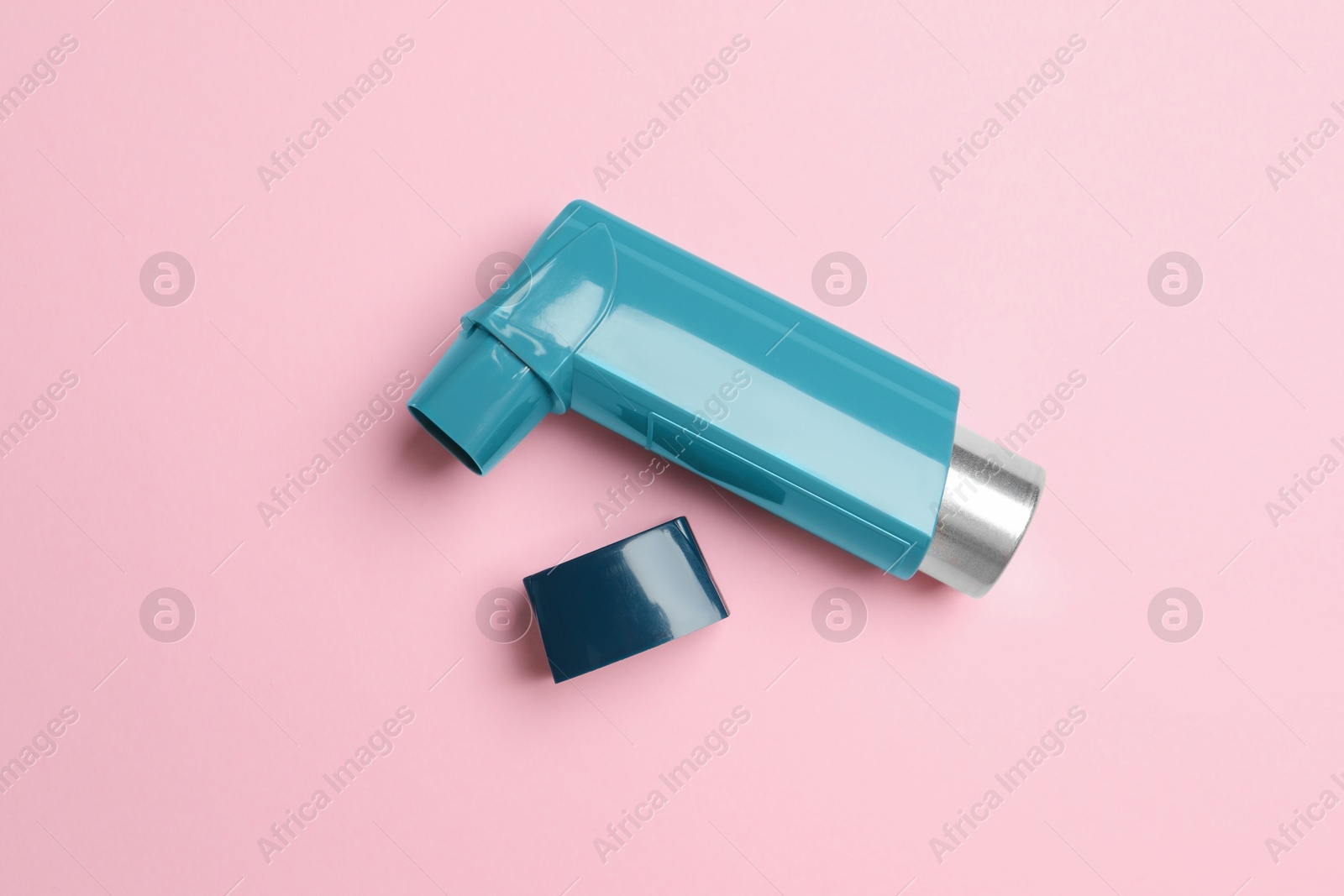 Photo of Asthma inhaler on pink background, top view