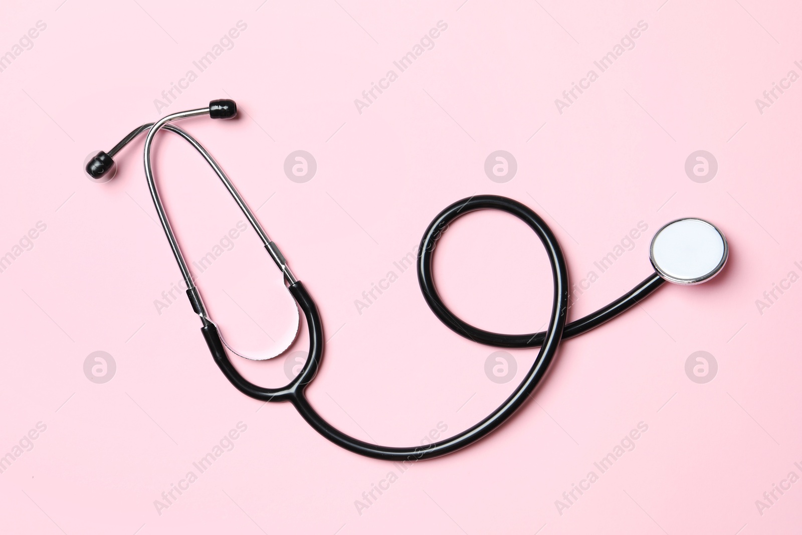 Photo of Stethoscope on pink background, top view. Medical treatment