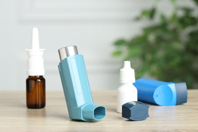 Photo of Different asthma medications on wooden table, closeup