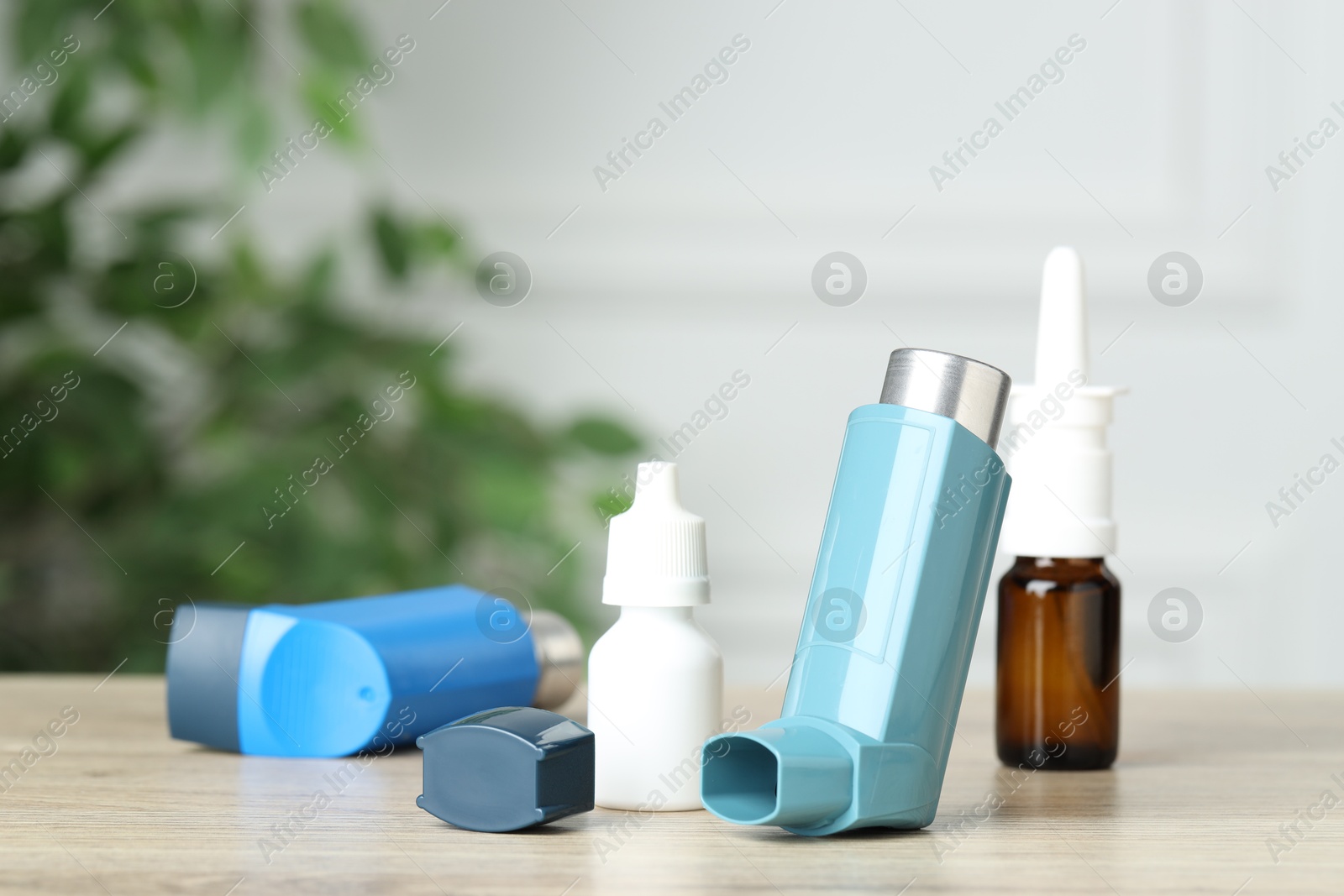 Photo of Different asthma medications on wooden table, closeup