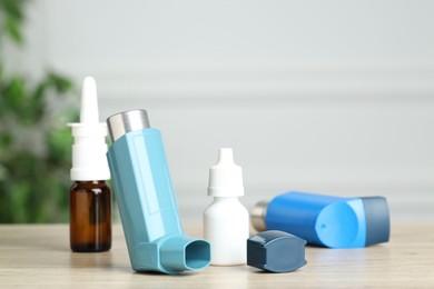 Photo of Different asthma medications on wooden table, closeup