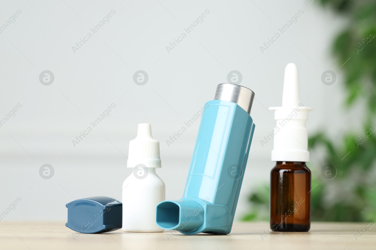 Photo of Different asthma medications on wooden table, closeup