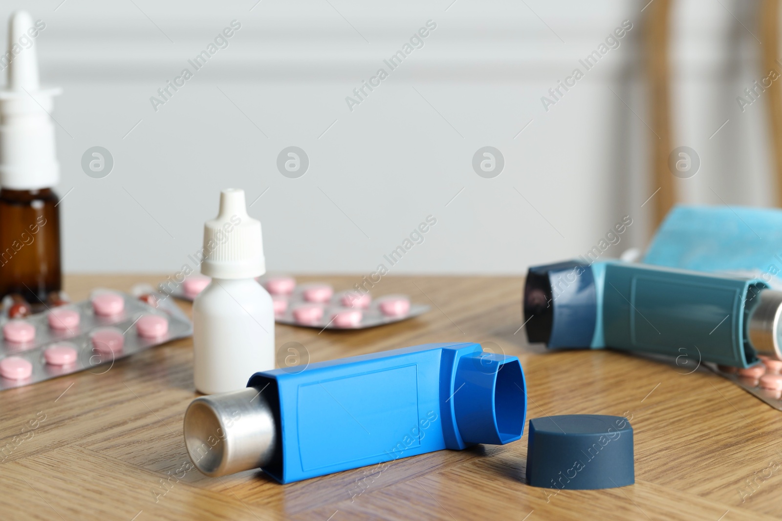 Photo of Different asthma medications on wooden table, closeup