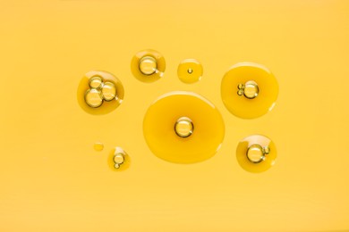 Photo of Sample of cosmetic oil on golden background, macro view