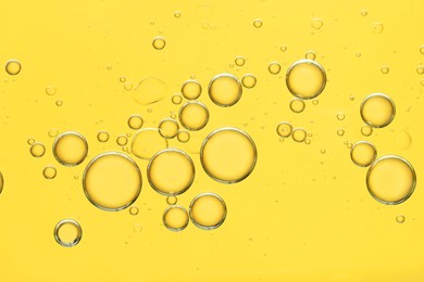 Photo of Sample of cosmetic oil on golden background, macro view