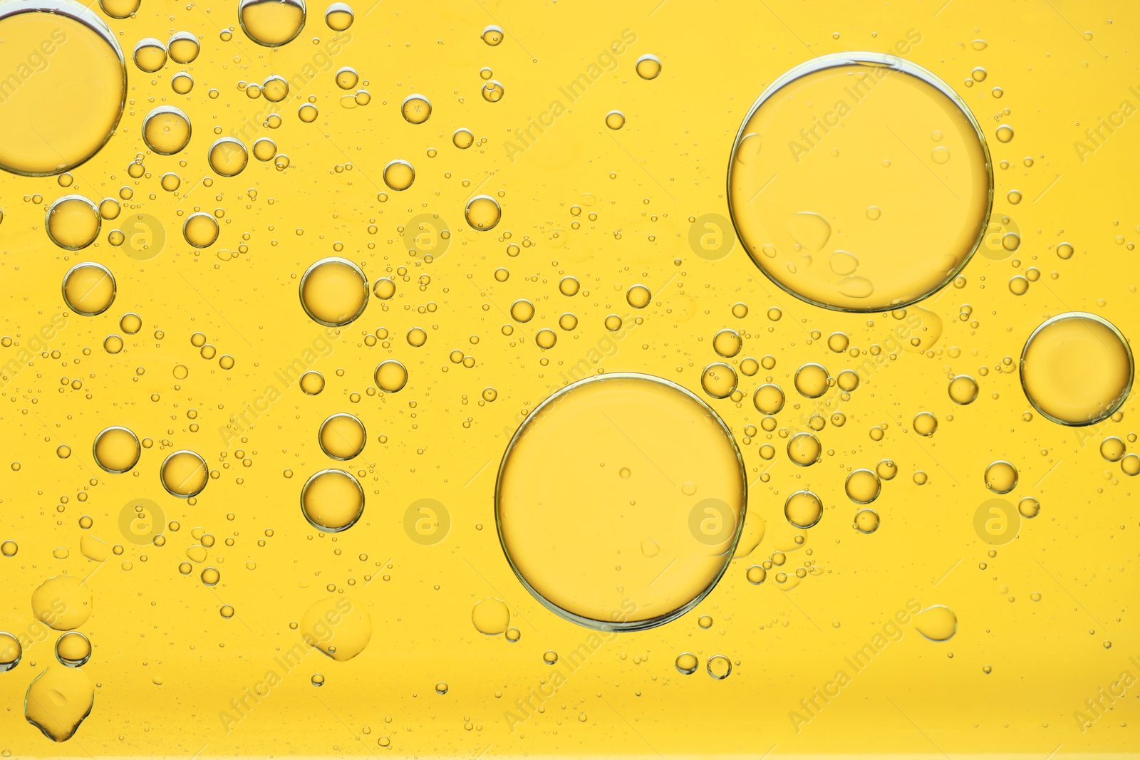 Photo of Sample of cosmetic oil on golden background, macro view