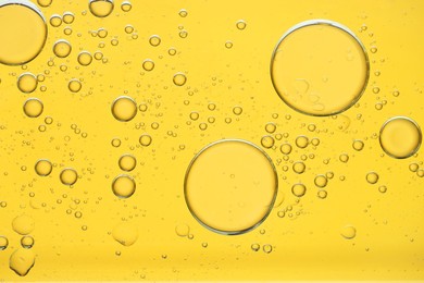 Photo of Sample of cosmetic oil on golden background, macro view