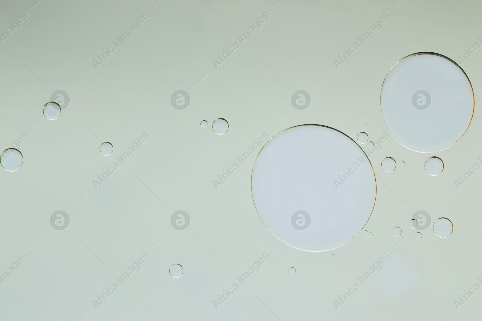 Photo of Sample of cosmetic oil on light grey background, macro view