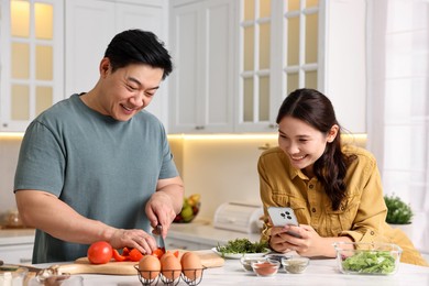 Happy lovely couple cooking together in kitchen