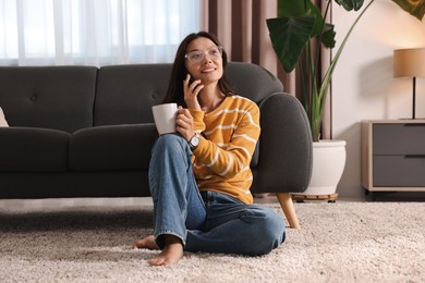 Smiling woman talking on smartphone at home