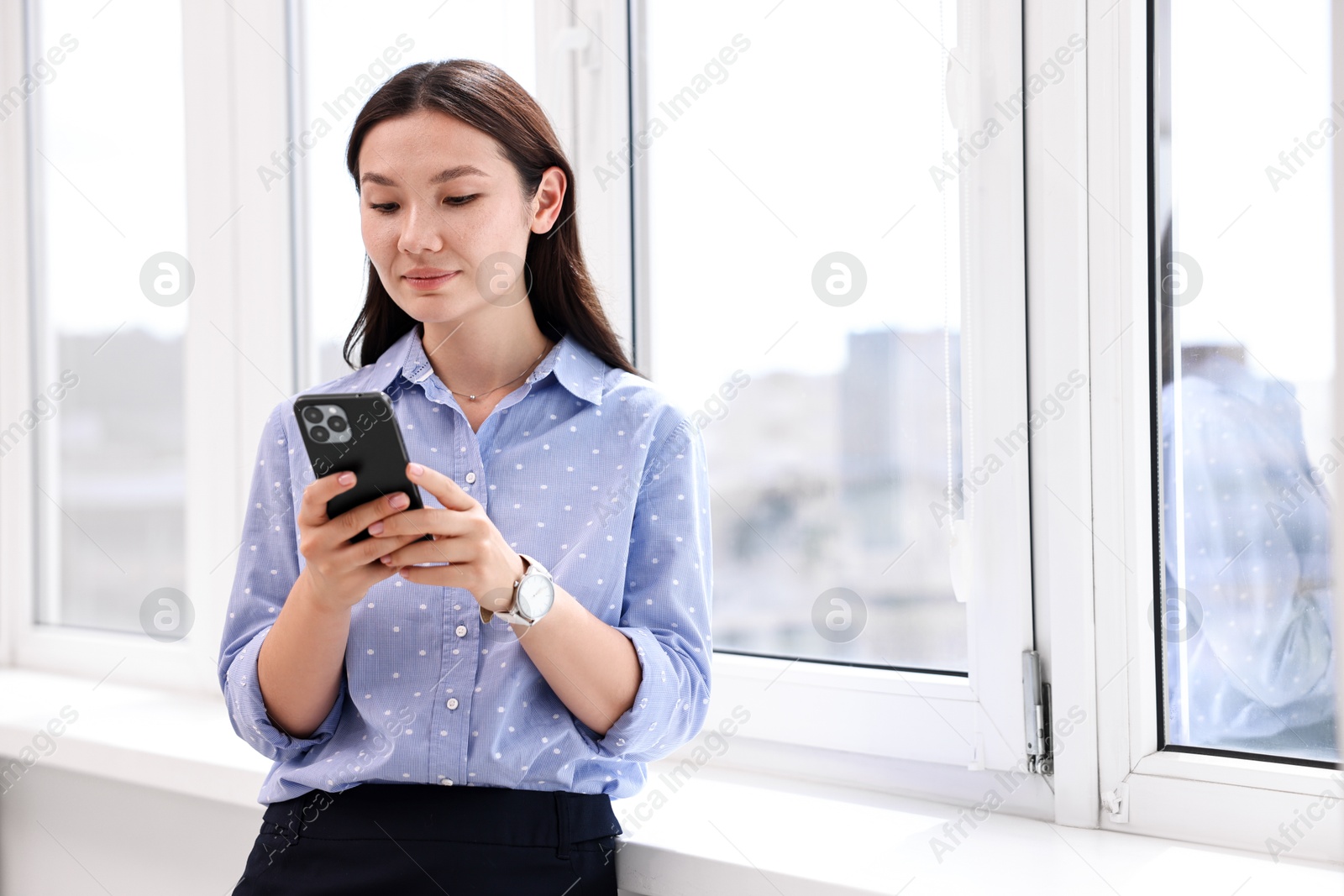 Photo of Beautiful businesswoman with smartphone in office. Space for text