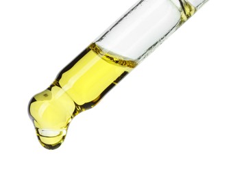 Photo of Dripping essential oil from pipette on white background