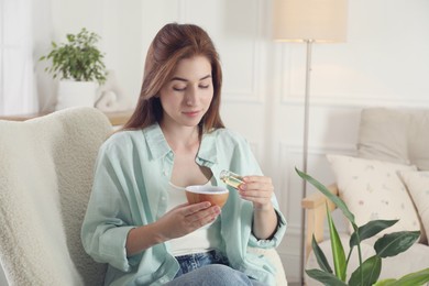 Woman adding essential oil to aroma diffuser at home