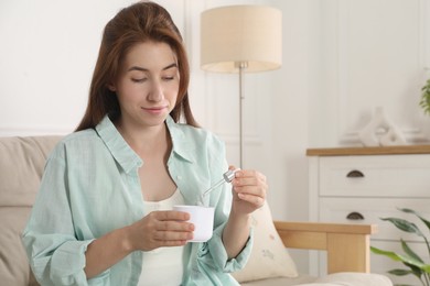 Photo of Woman adding essential oil to aroma diffuser at home