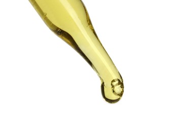 Dripping essential oil from pipette on white background