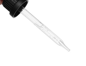 Dripping cosmetic serum from pipette on white background