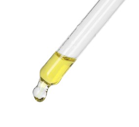 Dripping essential oil from pipette on white background