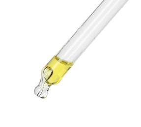 Dripping essential oil from pipette on white background