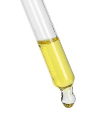 Dripping essential oil from pipette on white background