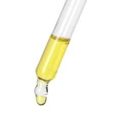 Dripping essential oil from pipette on white background