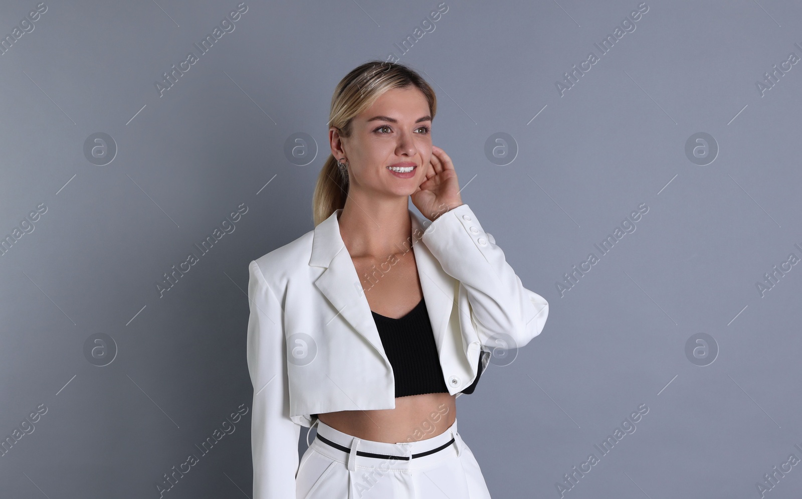 Photo of Beautiful woman in stylish white suit on grey background