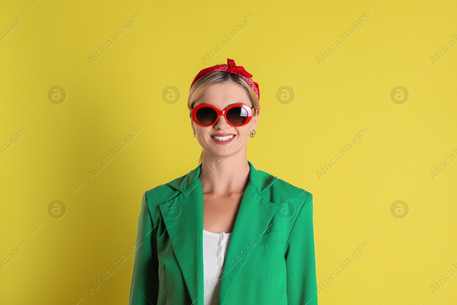 Photo of Beautiful woman in stylish green jacket on yellow background