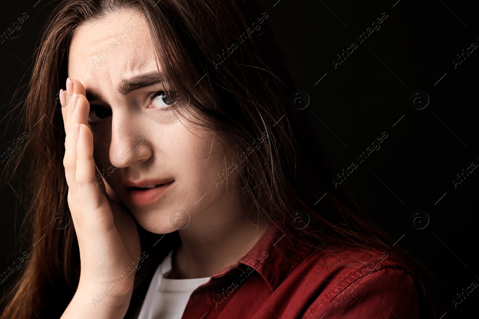 Photo of Portrait of scared woman on black background