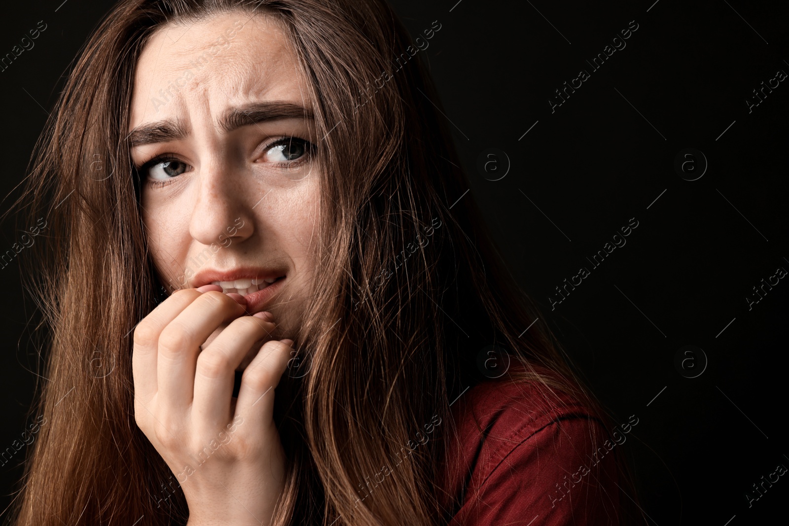 Photo of Portrait of scared woman on black background