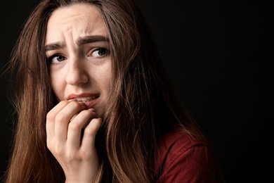 Photo of Portrait of scared woman on black background