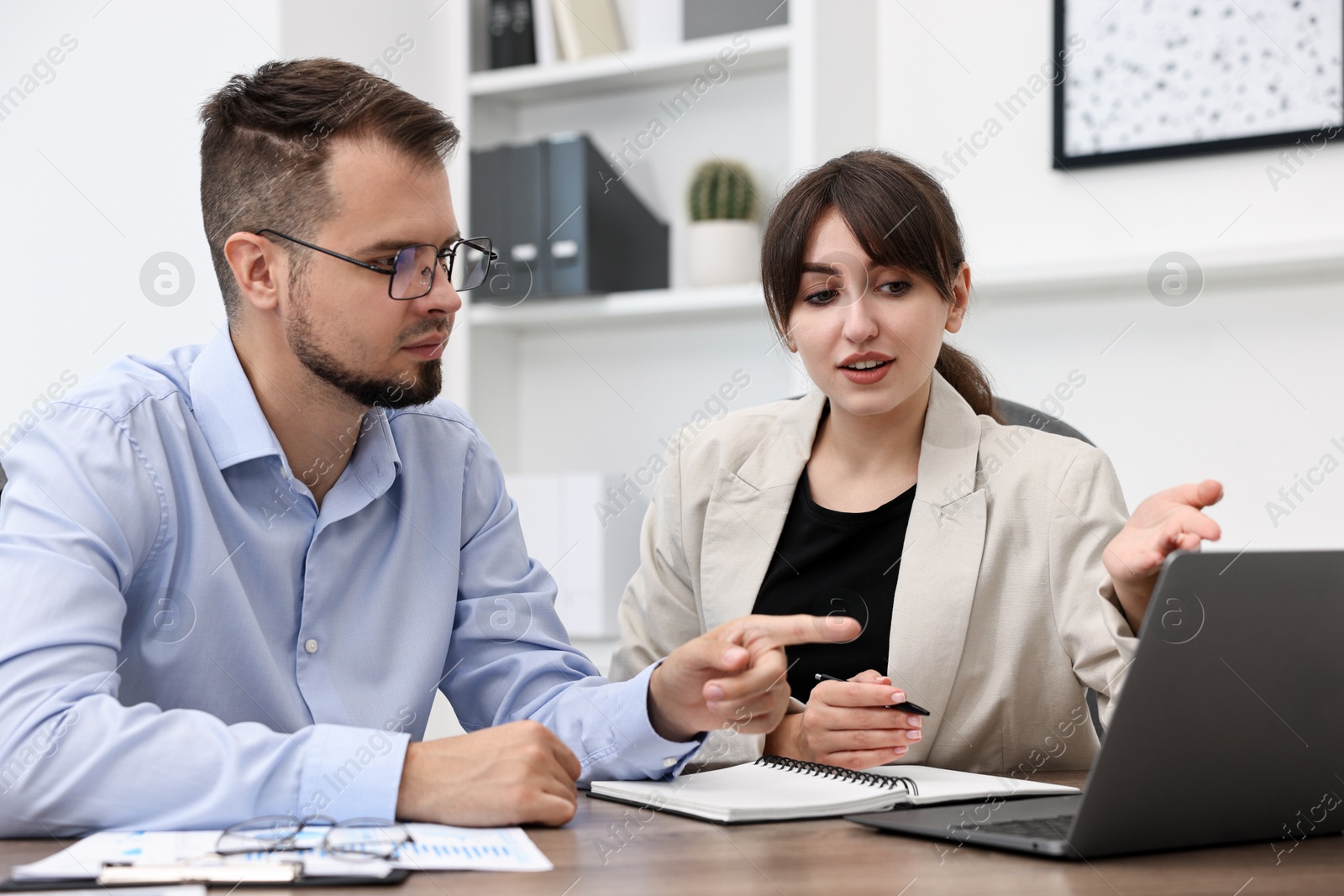 Photo of Consultant working with client at table in office. Business meeting