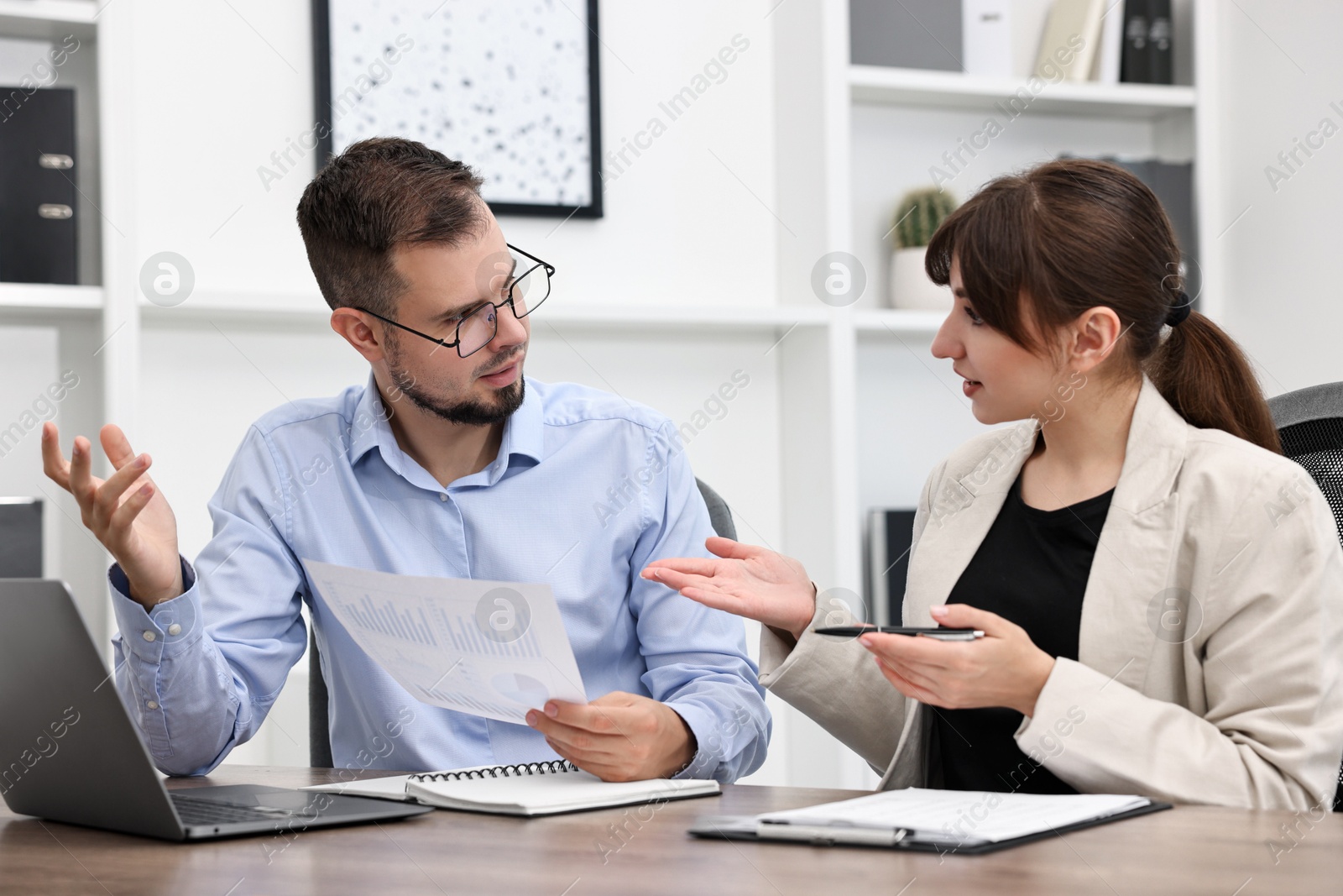 Photo of Consultant working with client at table in office. Business meeting