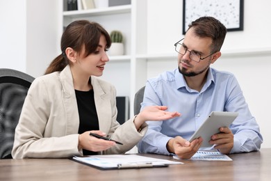 Consultant working with client at table in office. Business meeting