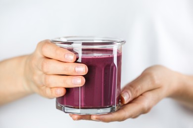 Photo of Woman with glass of tasty fresh acai juice, closeup