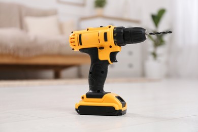 Photo of Cordless electric screwdriver on floor at home