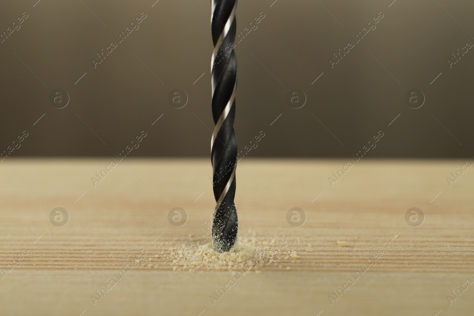 Photo of Drilling hole in wooden plank on grey background, closeup