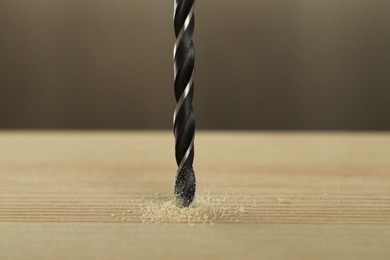 Photo of Drilling hole in wooden plank on grey background, closeup