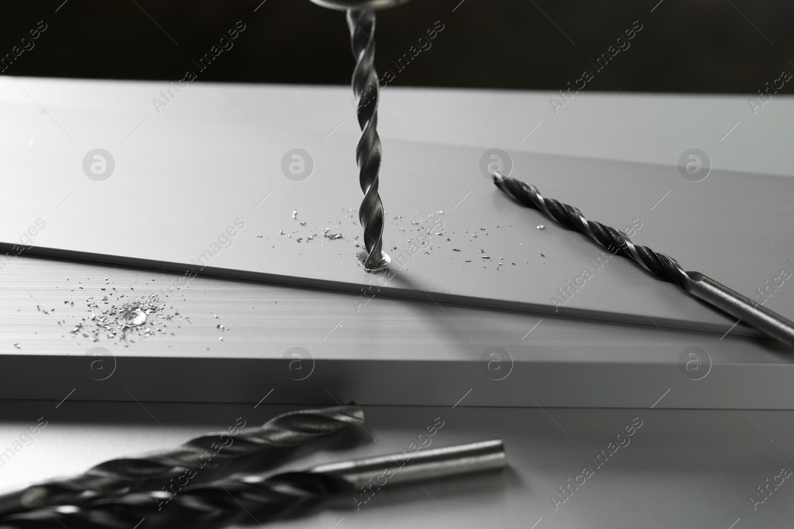 Photo of Drilling hole in plank on light table, closeup