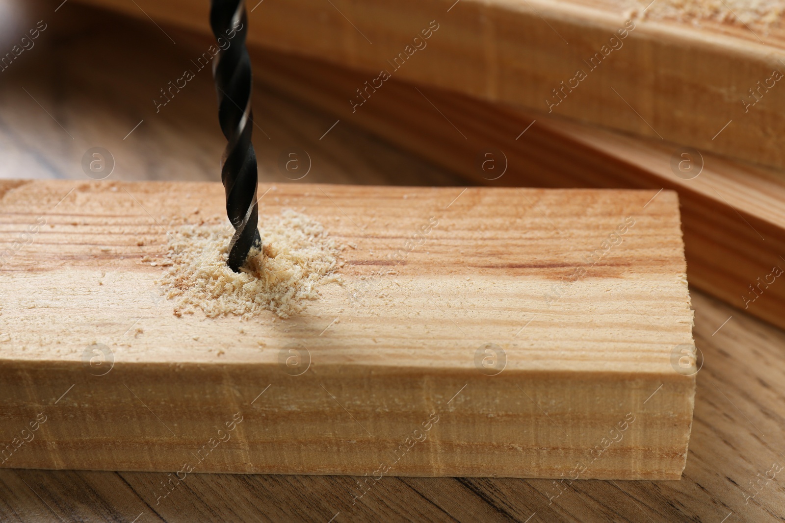 Photo of Drilling hole in plank on wooden table, closeup