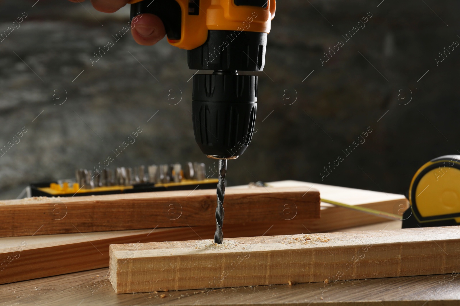 Photo of Drilling hole in plank on wooden table, closeup