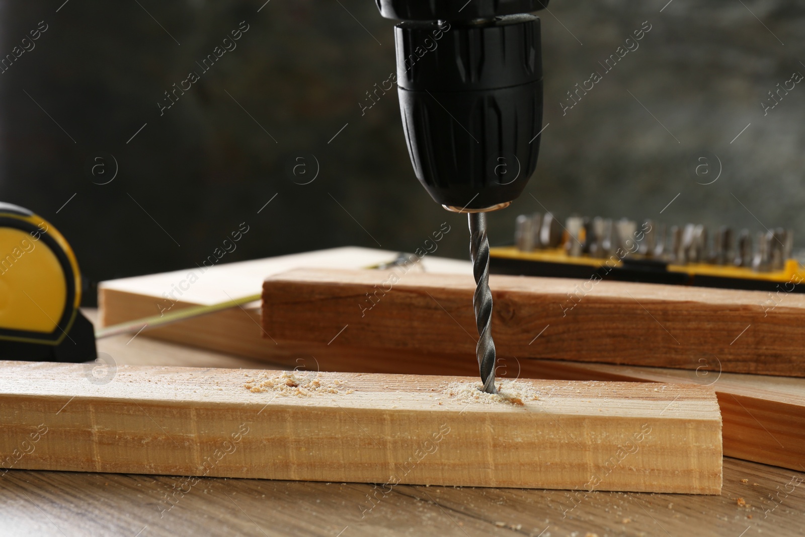 Photo of Drilling hole in plank on wooden table, closeup